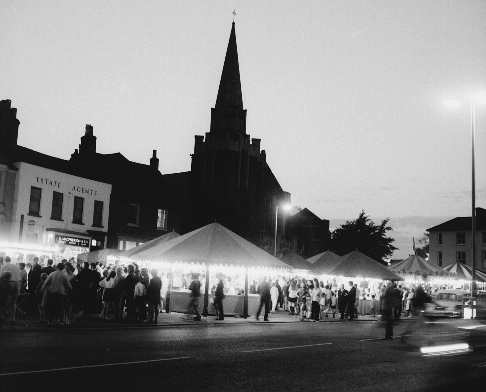 Stalls with lights at night with church shadow in background